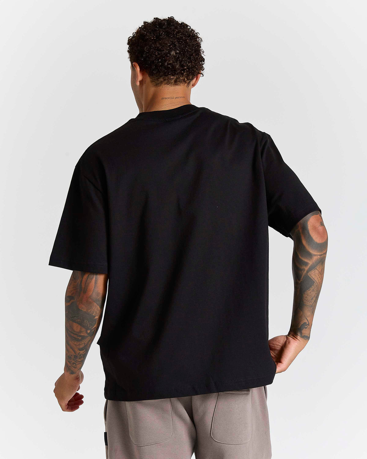 Displays a model wearing the Black 'Hoodrich' branded Inkline V2 Oversized Tshirt