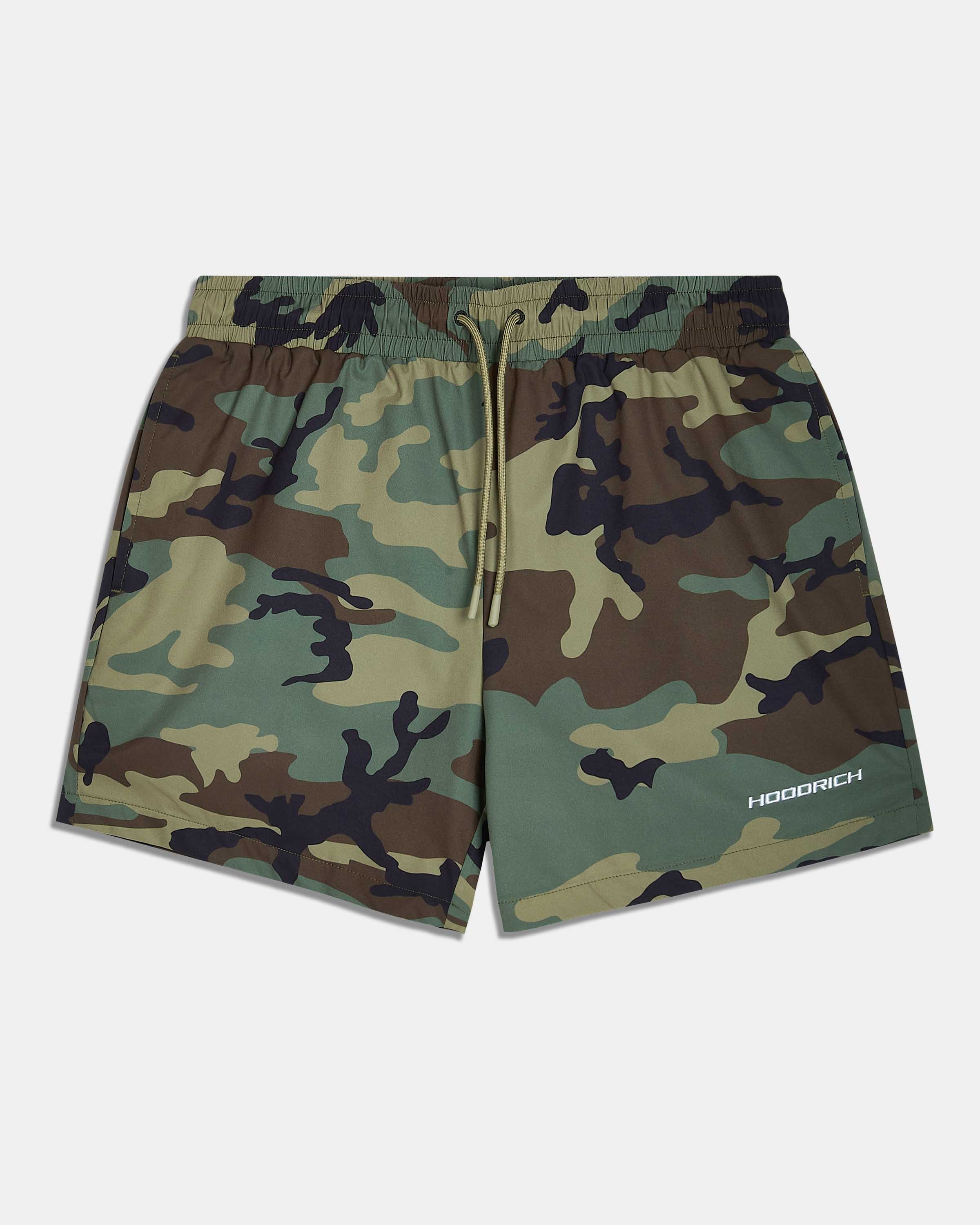 A pair of camouflage print athletic shorts with a green, brown, and black camo pattern, featuring a drawstring waist and a white 'HOODRICH' logo on the lower left leg, displayed against a light gray background.