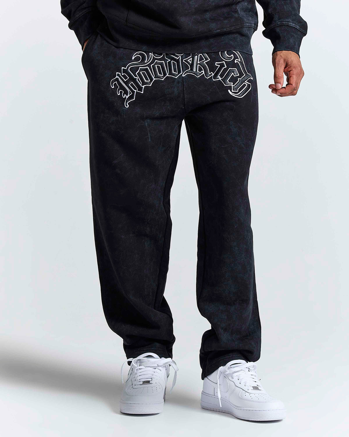 Displays a model wearing the Black 'Hoodrich' branded men's Nocturn Full Tracksuit
