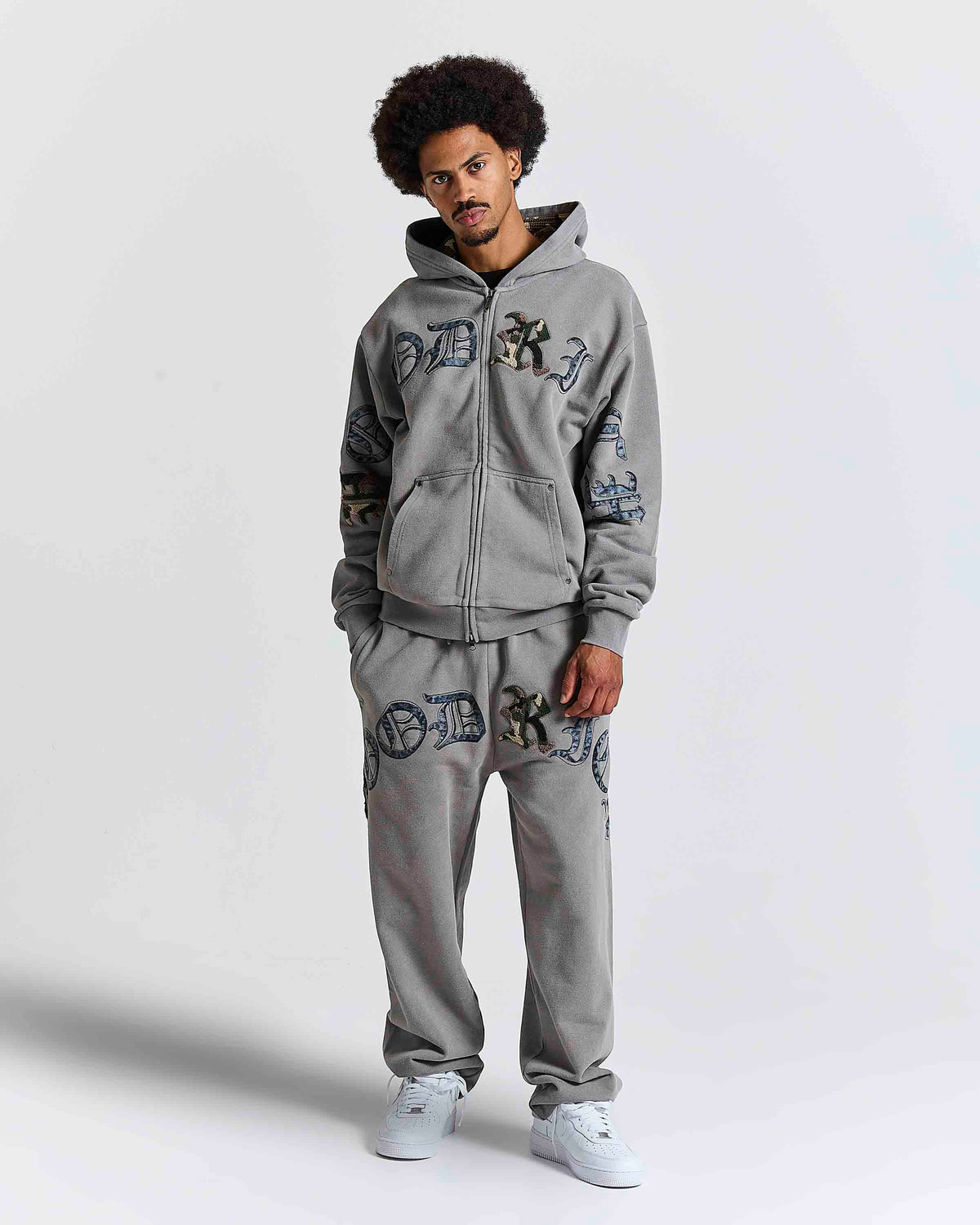 Displays a model wearing the Grey 'Hoodrich' branded men's Inkfall Full Tracksuit