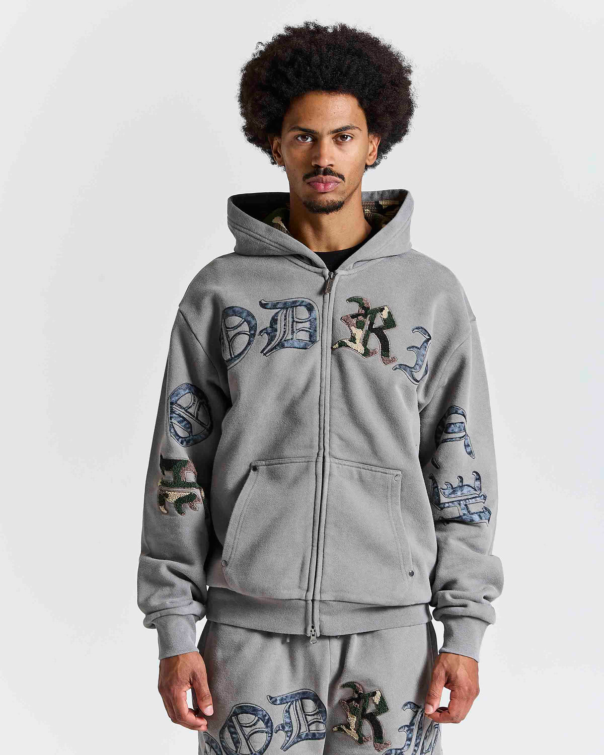 Displays a model wearing the Grey 'Hoodrich' branded men's Inkfall Full Tracksuit
