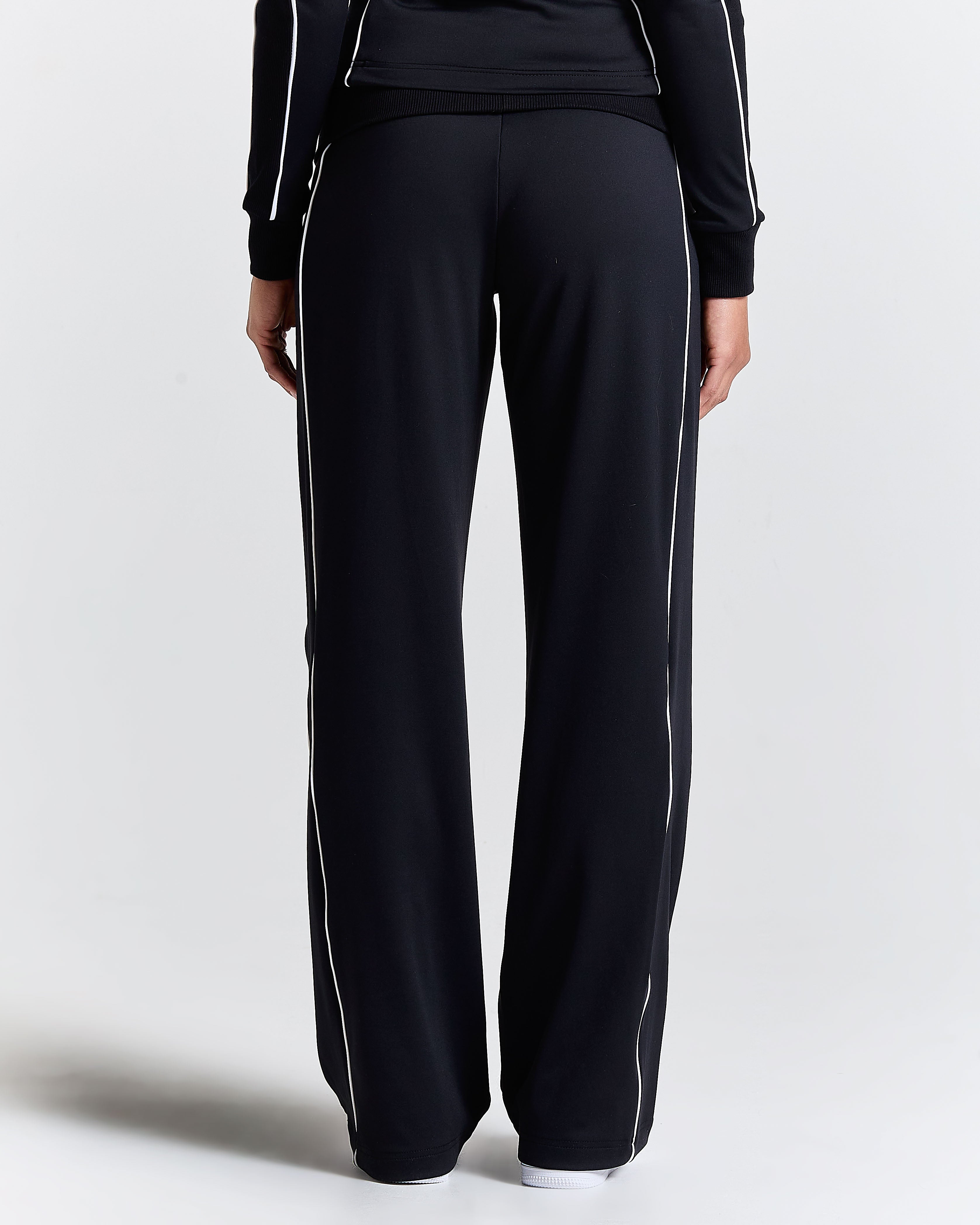 Black tracksuit with white stripes on a light gray background
