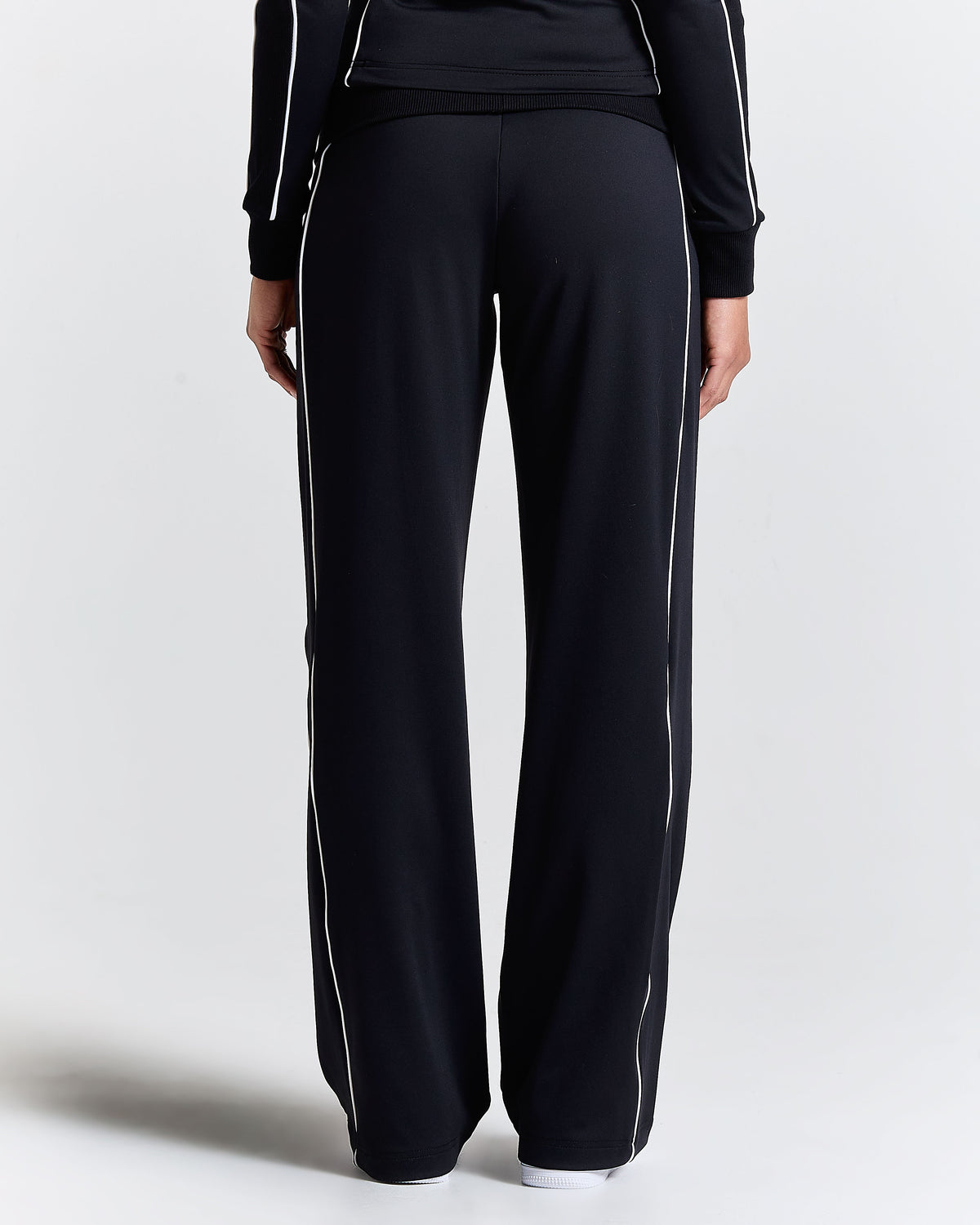 Displays a model wearing the Black 'Hoodrich' branded women's Glide Football Full Tracksuit