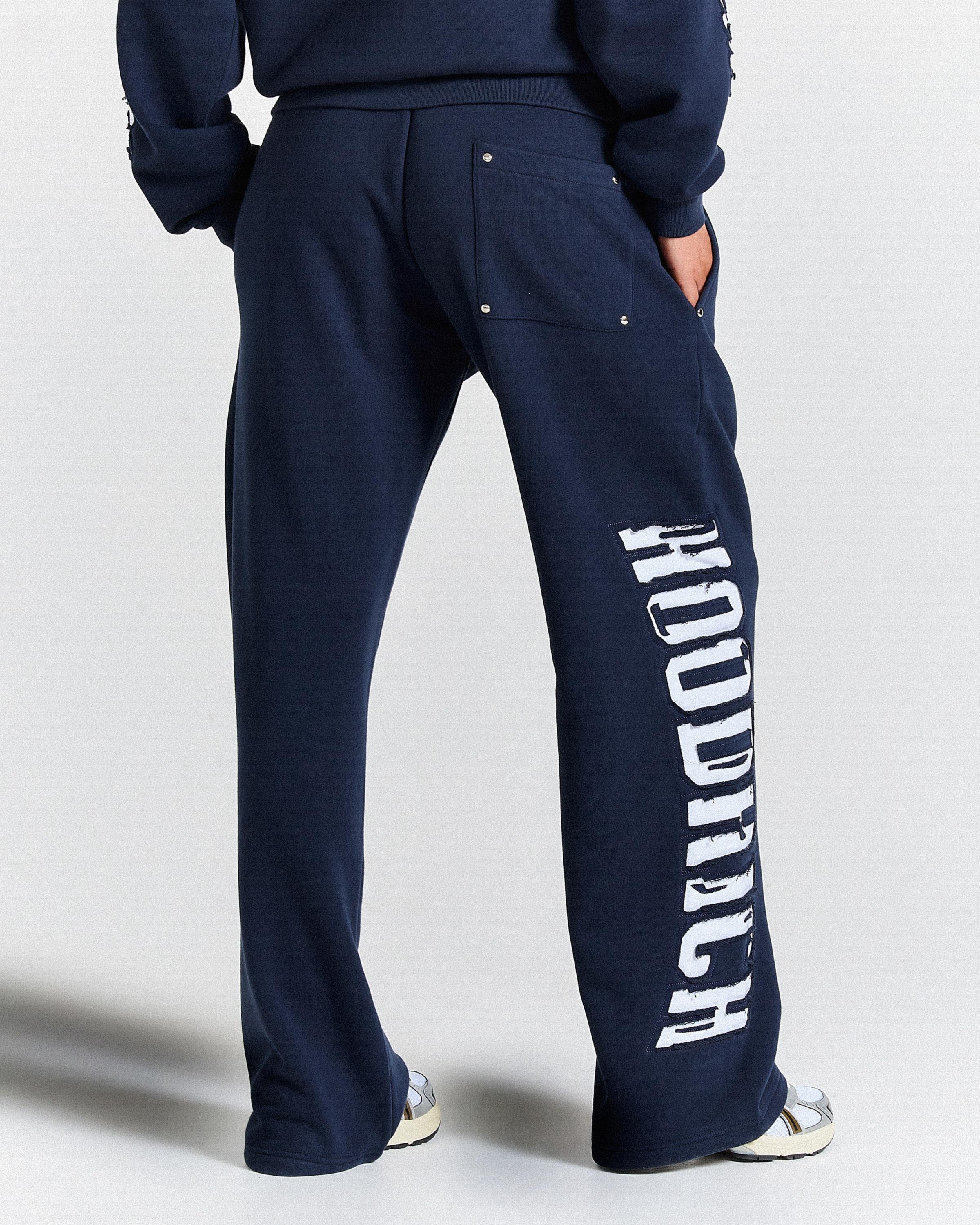 Navy blue sweatpants with 'Hoodrich' branding on a light gray background