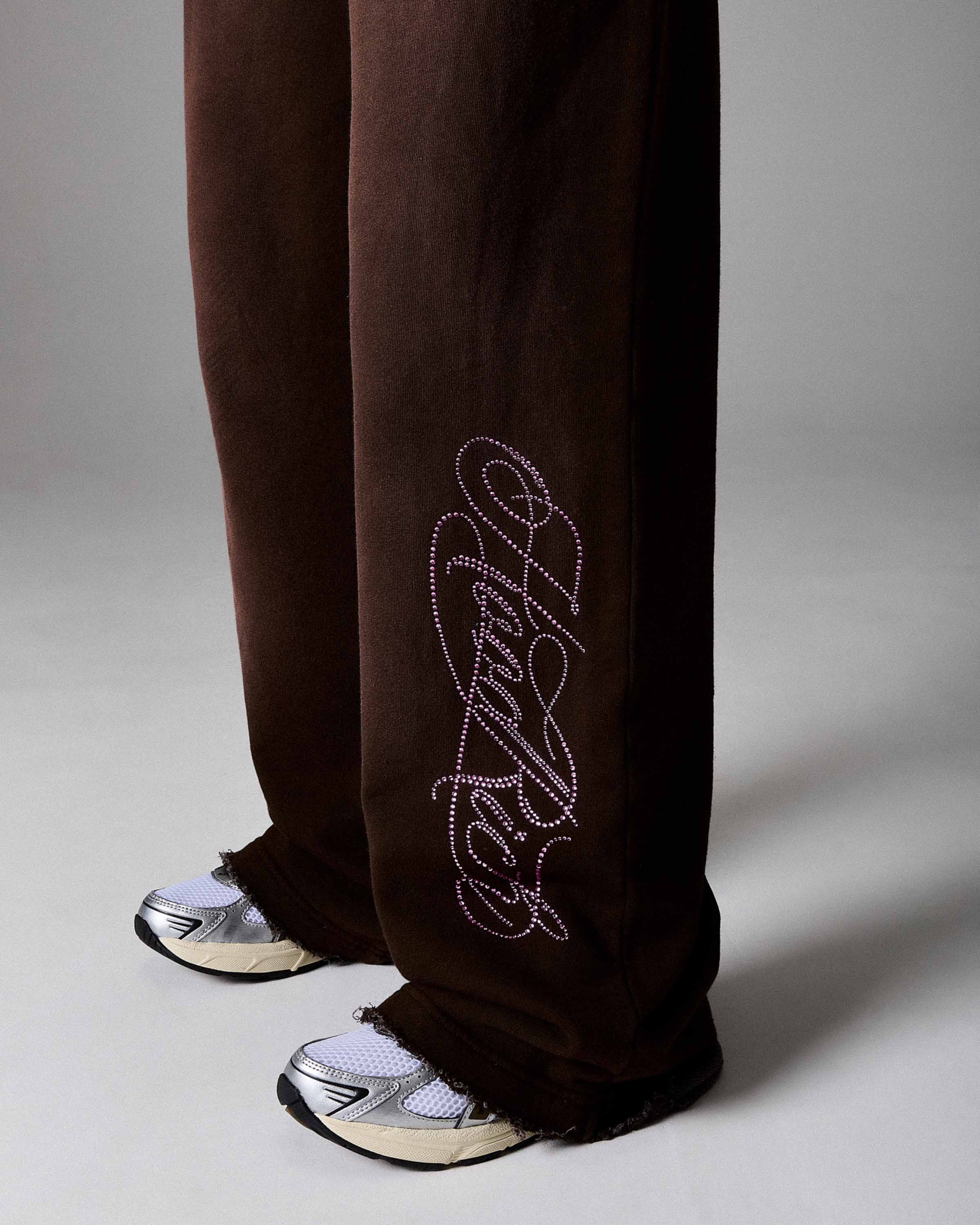 Brown pants with a decorative logo on a gray background