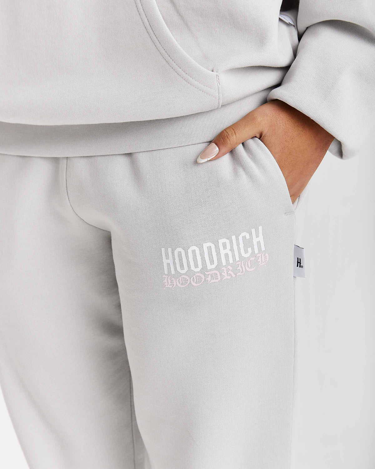 Displays a model wearing the Grey 'Hoodrich' branded women's Flex Full Tracksuit featuring the hoodrich branding details