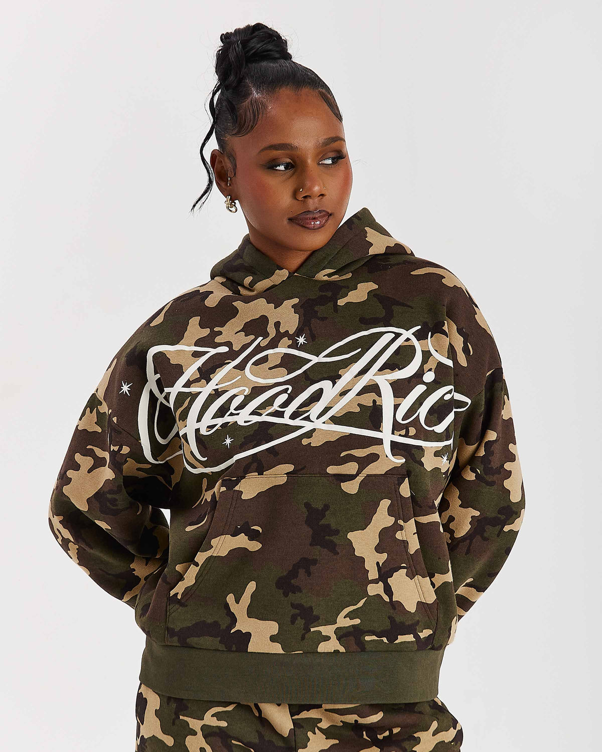 Displays a model wearing the Camo 'Hoodrich' branded women's Solace Full Tracksuit