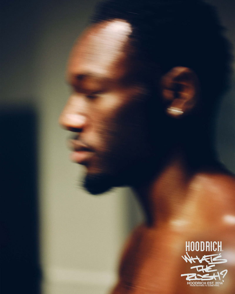Man with a blurred background and 'Hoodrich' logo in the corner