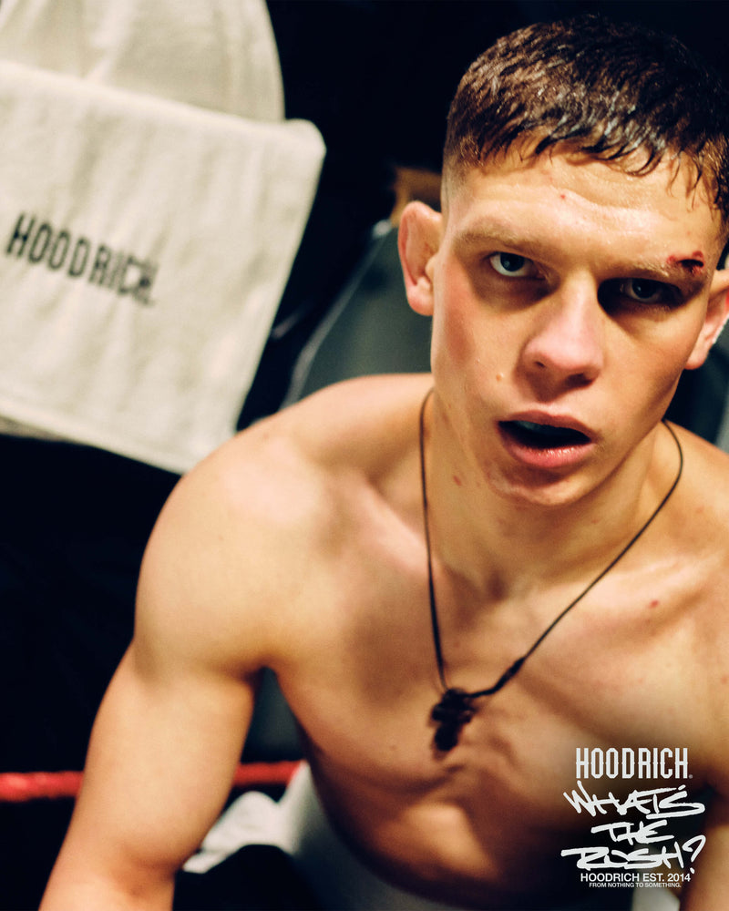 Man in a boxing ring with 'Hoodrich' branding