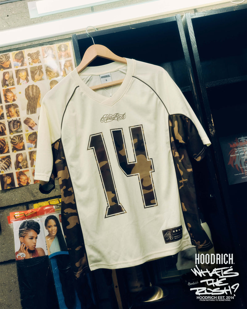 White sports jersey with camouflage sides and number 14 on the front, on a hanger.