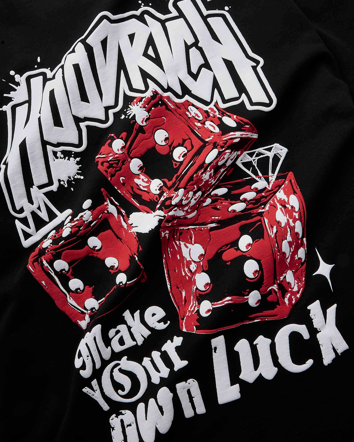 Close-up of a black graphic t-shirt featuring three red dice with white eyes and a white diamond, with stylized white text reading 'HOODRICH' and 'Make Your Own Luck'.