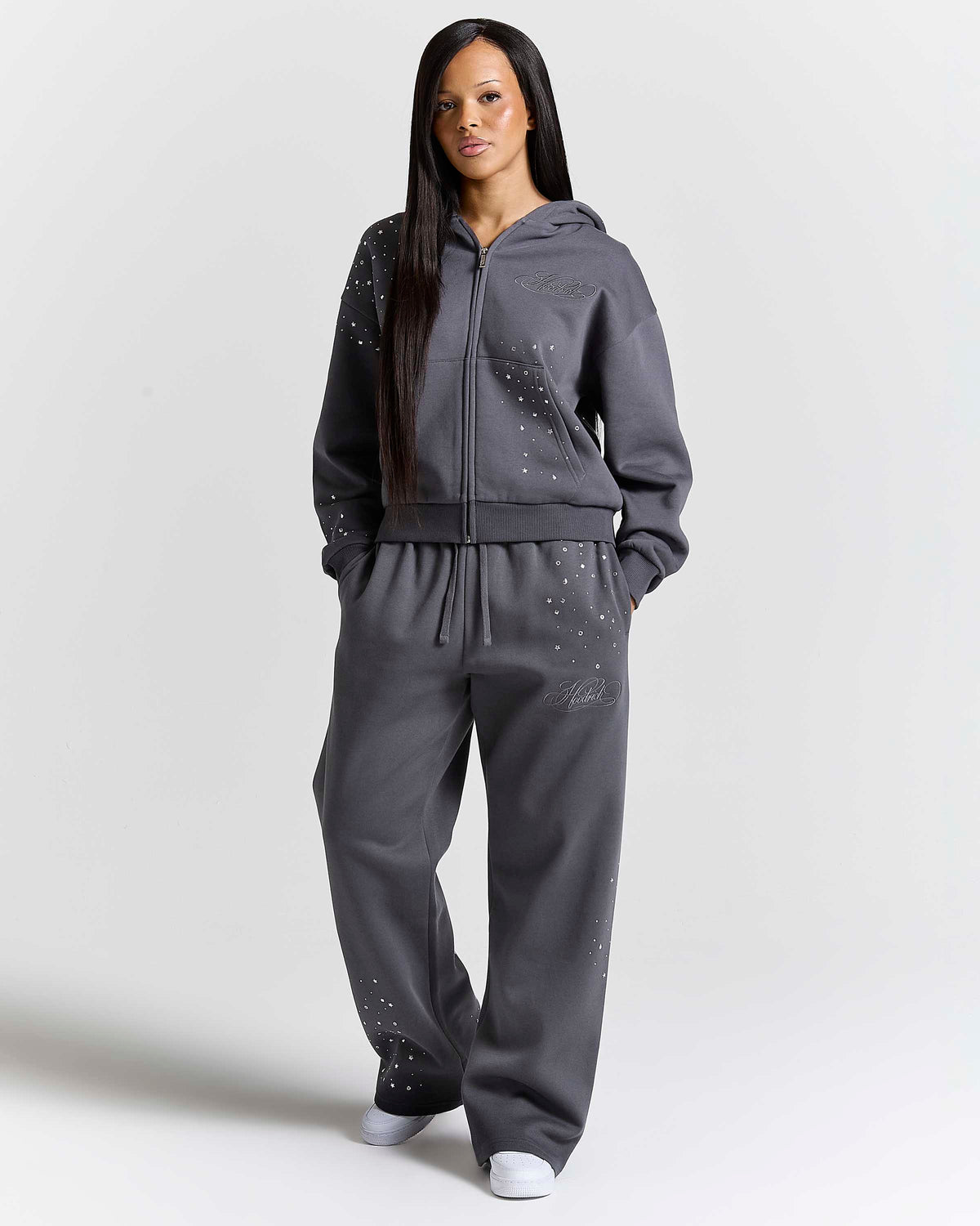 Displays a model wearing the Silver rhinestone 'Hoodrich' branded Clash V2 Mid Length Z/T Hoodie 