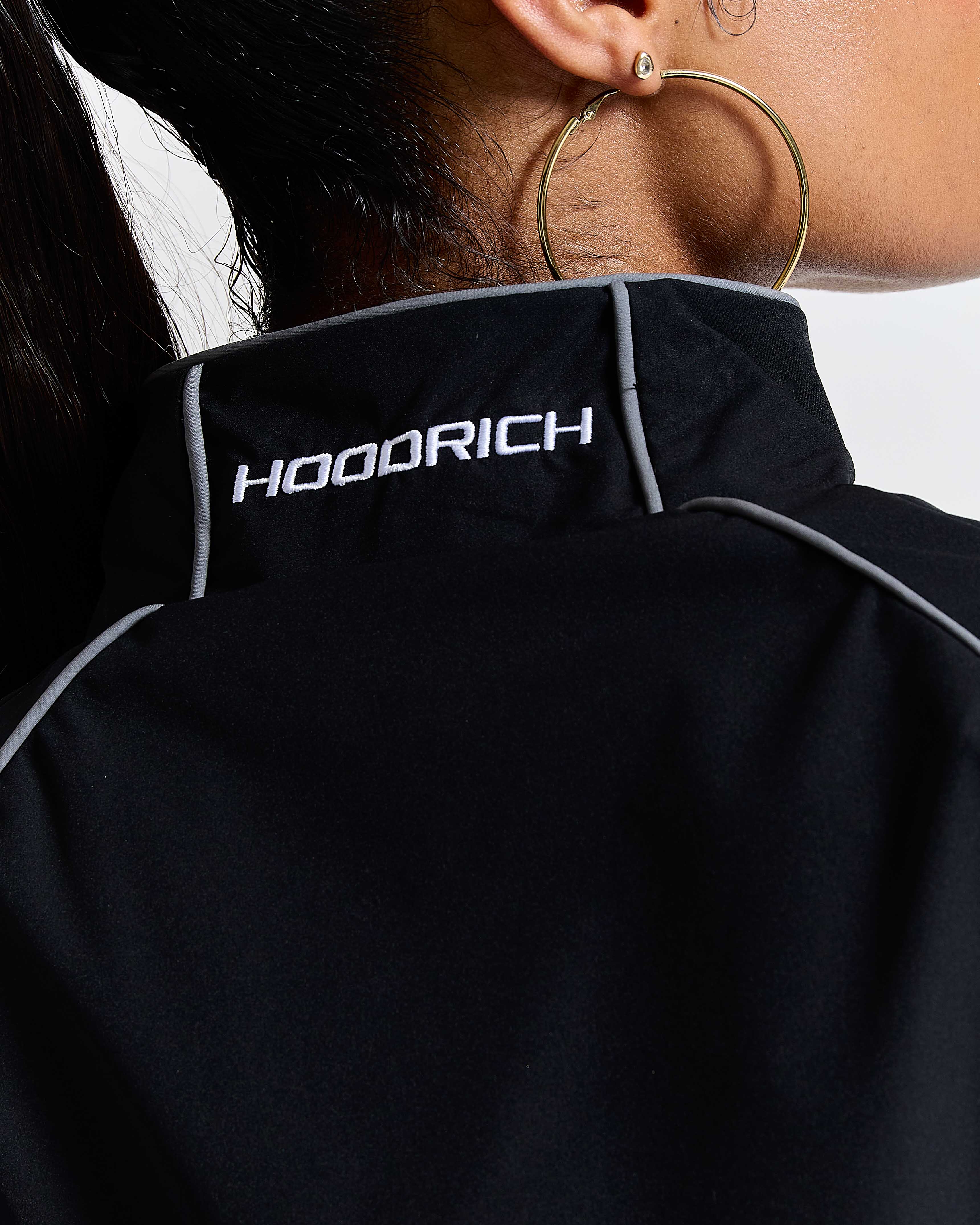Black hoodie with 'HOODRICH' branding on the chest, worn by a person.