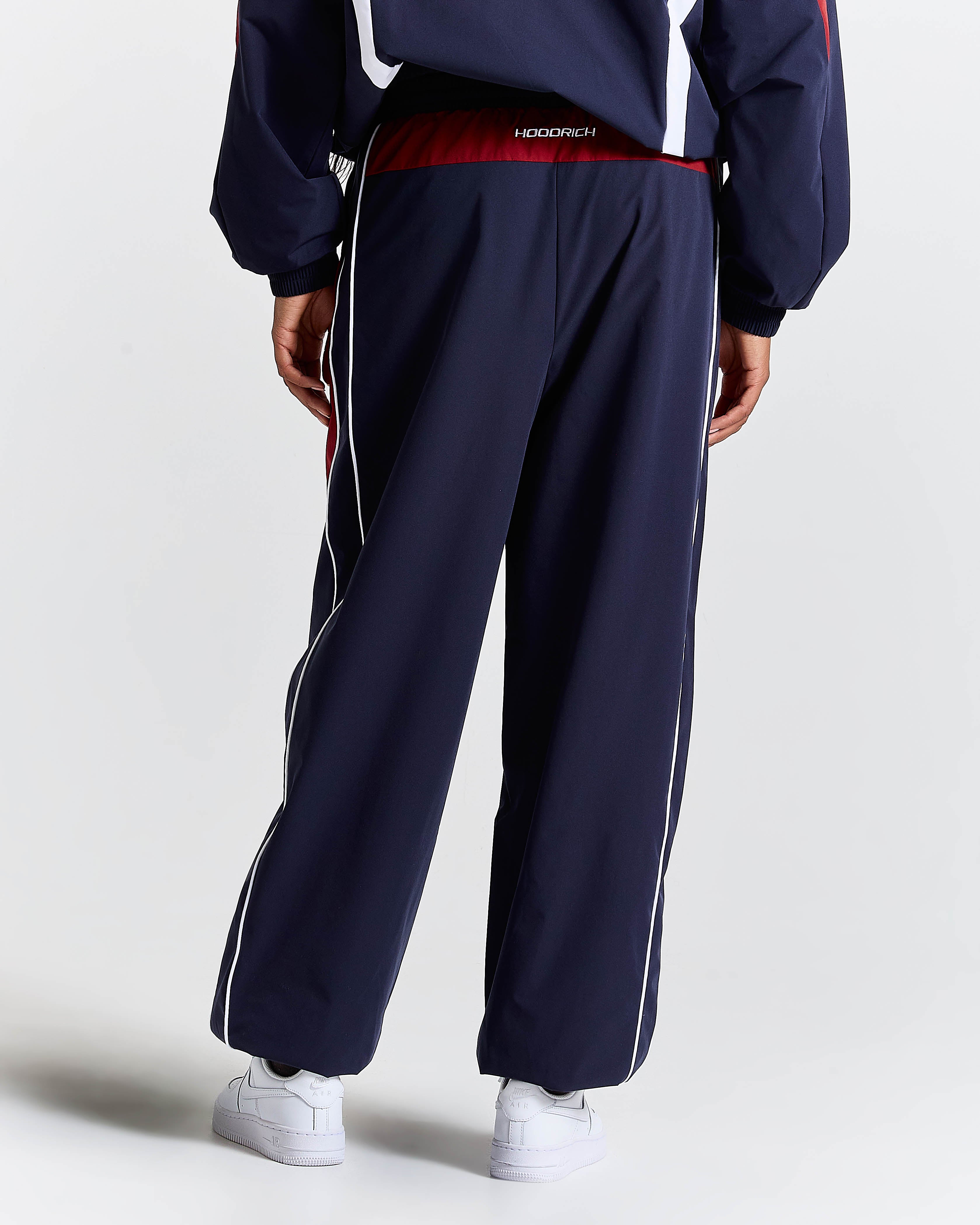 Navy tracksuit with white stripes on a light gray background