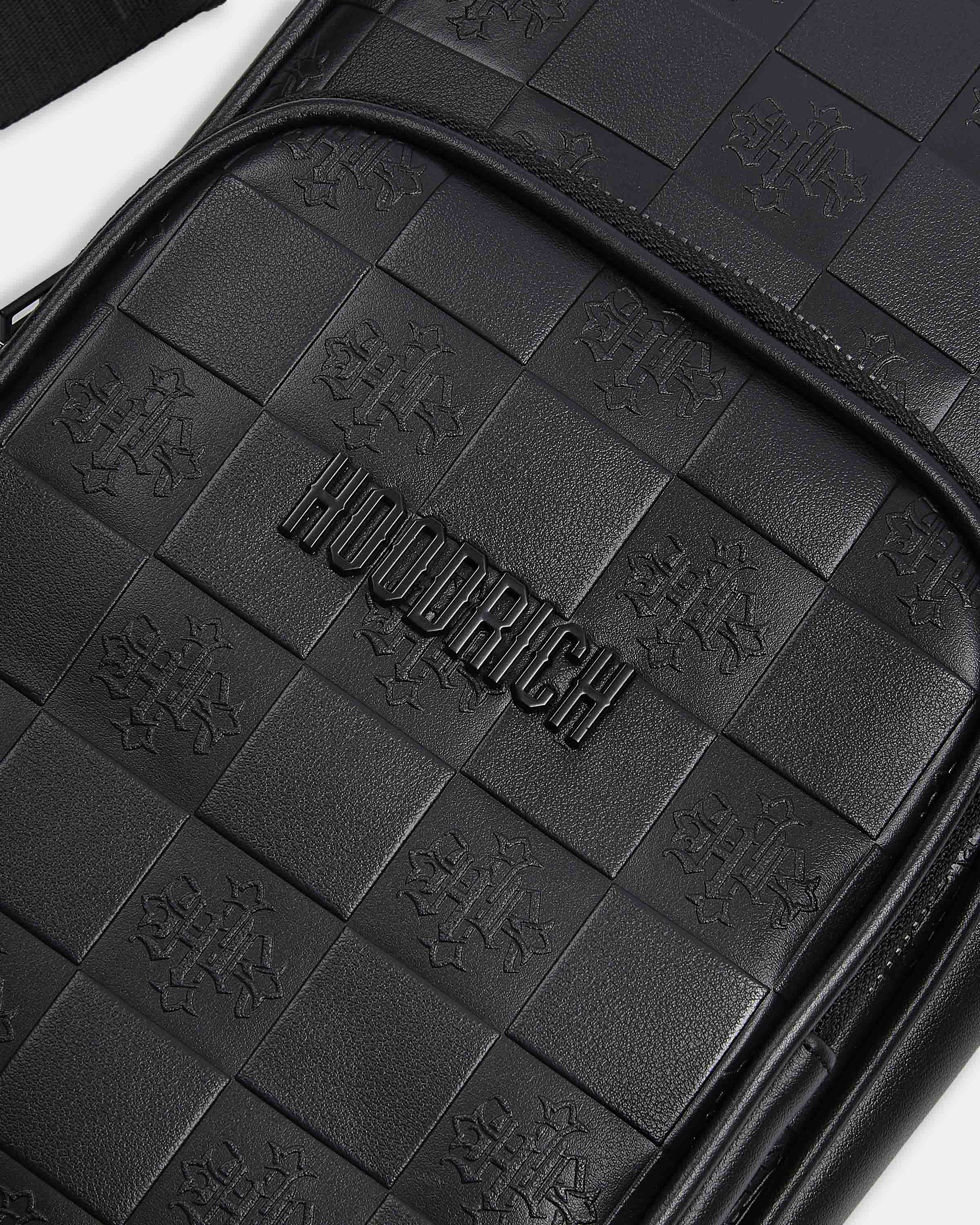 Close-up of a black leather product with 'HOODRICH' branding and quilted pattern.
