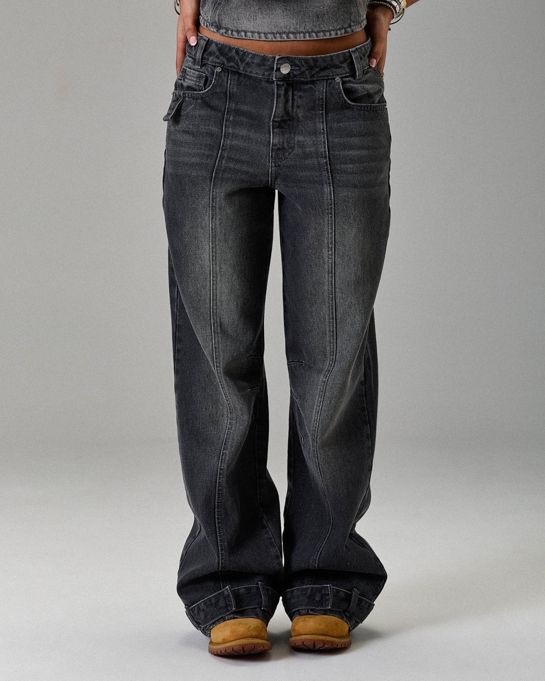 Black jeans worn by a person on a gray background