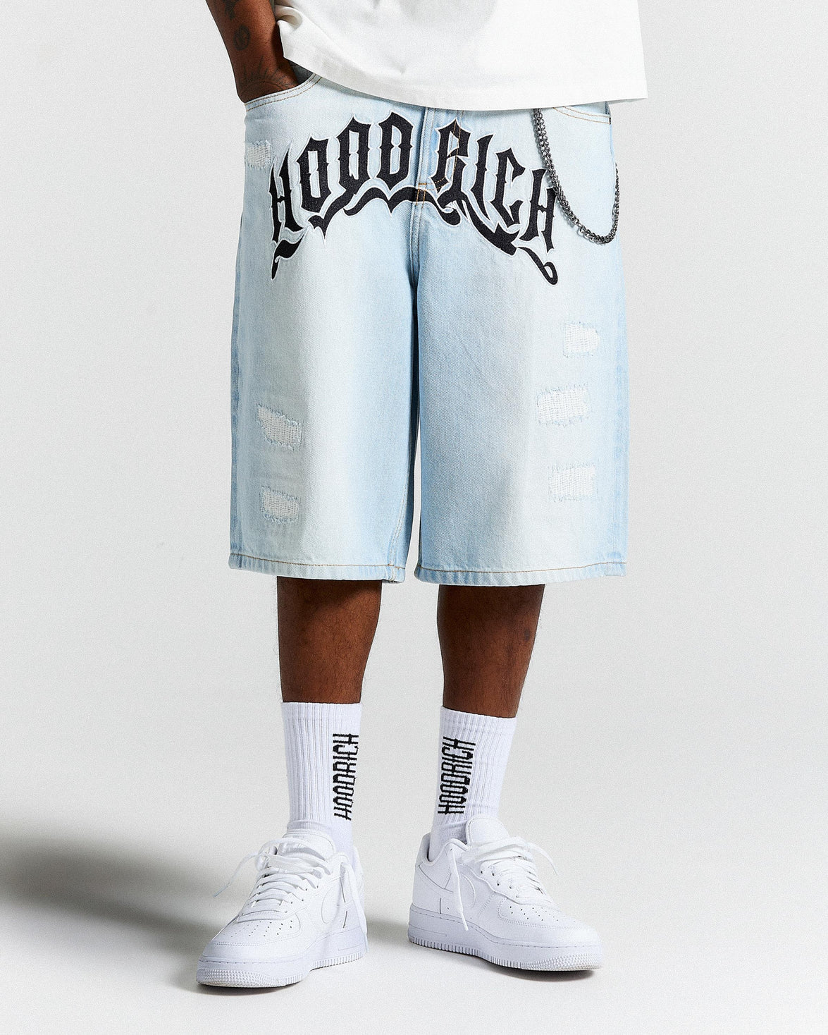 Light blue denim shorts with 'Hoodrich' branding worn by a person on a white background
