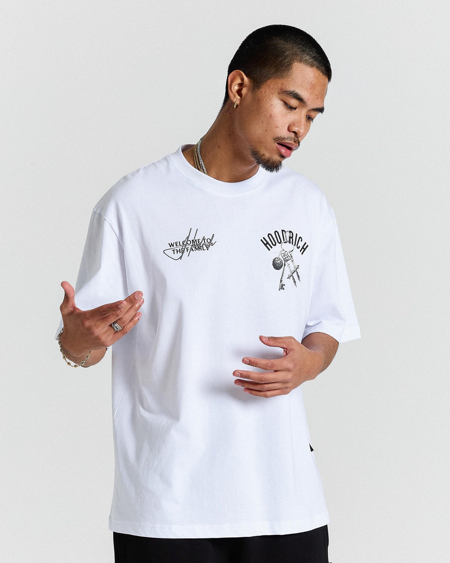 Man wearing a white t-shirt with graphics and text on a plain background