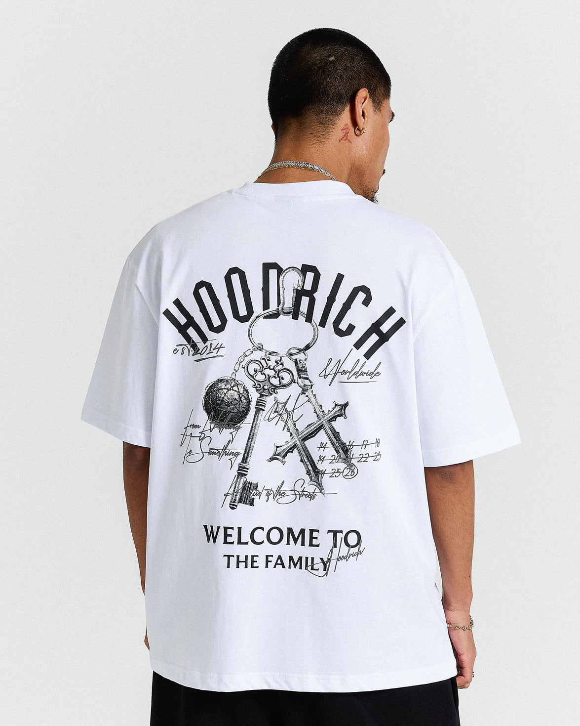 Person wearing a white t-shirt with black graphics and text on a plain background