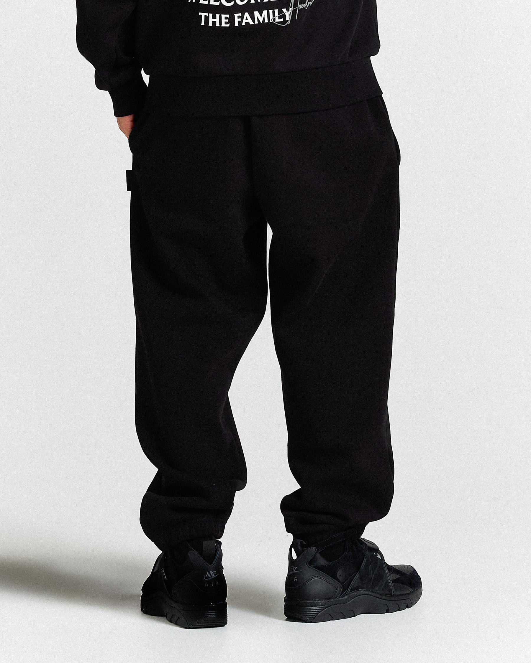 Person wearing black pants and shoes on a white background