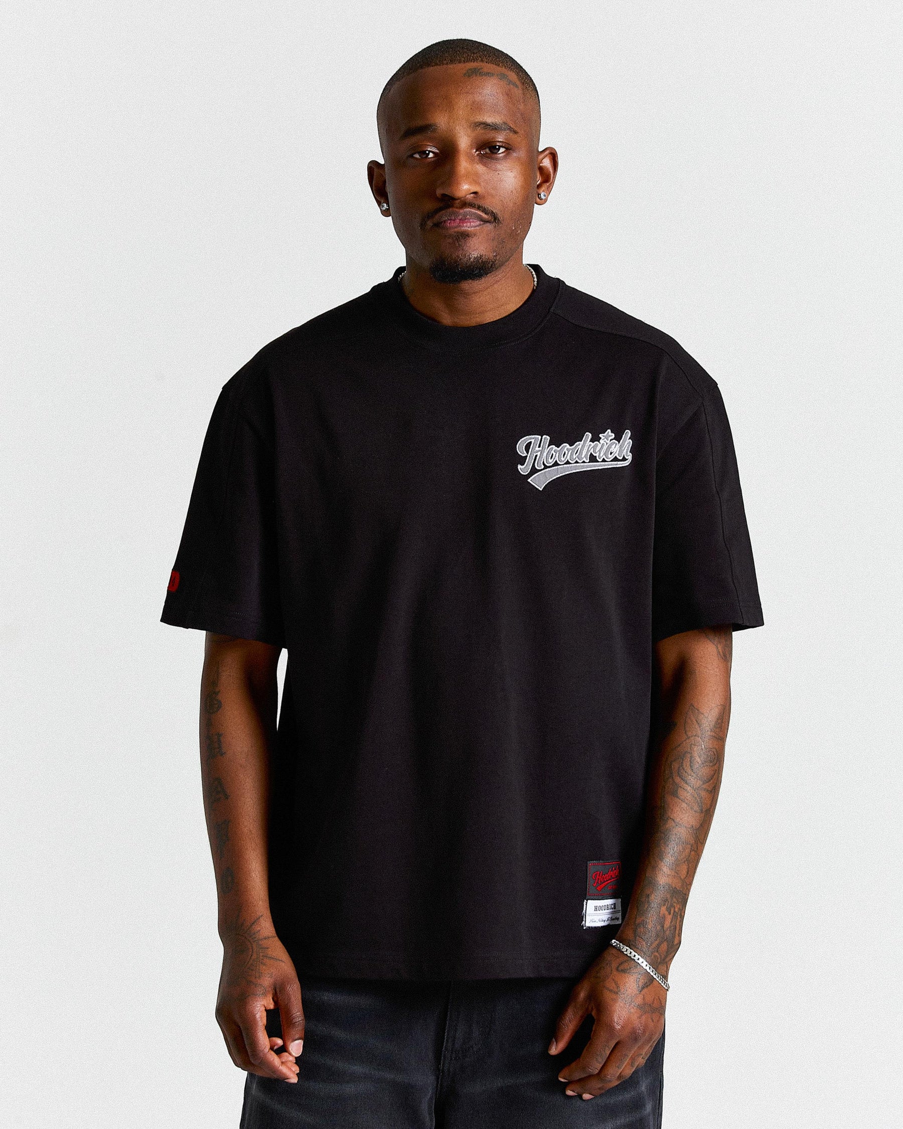 Man wearing a black t-shirt with a logo on a white background