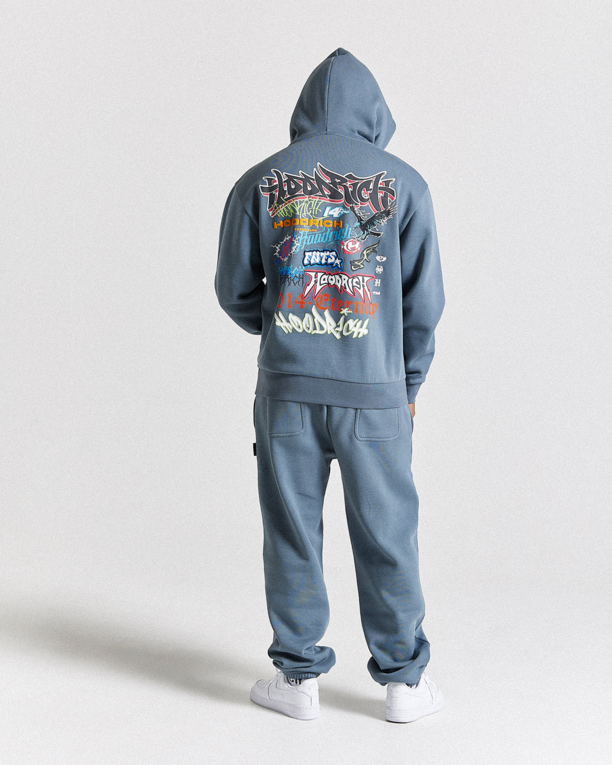 Displays a model wearing the Grey 'Hoodrich' branded men's Graff Rave Full Tracksuit