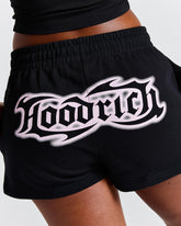 Black shorts with a white logo on a neutral background