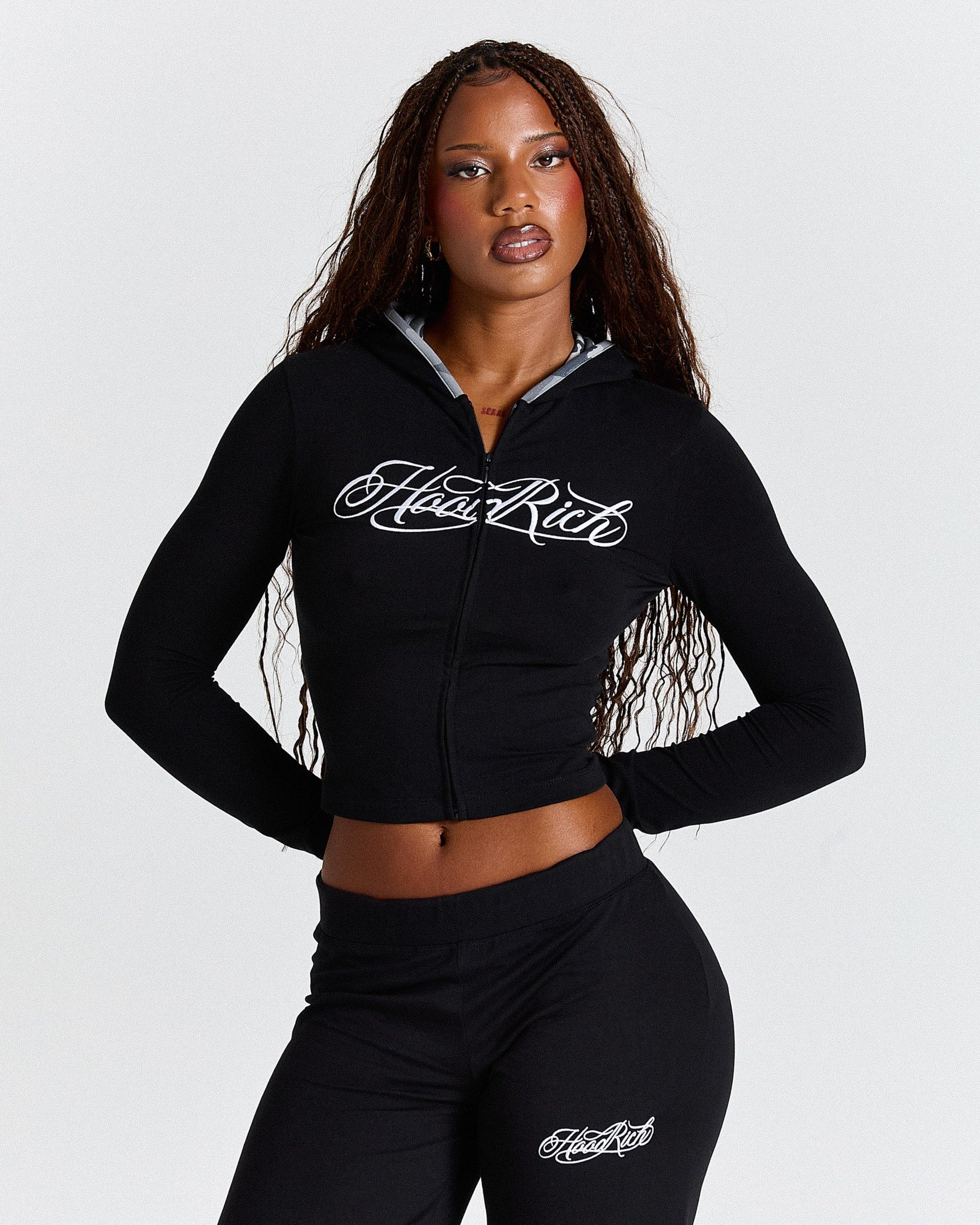 Woman wearing a black hoodie with 'Hoodrich' branding on a white background