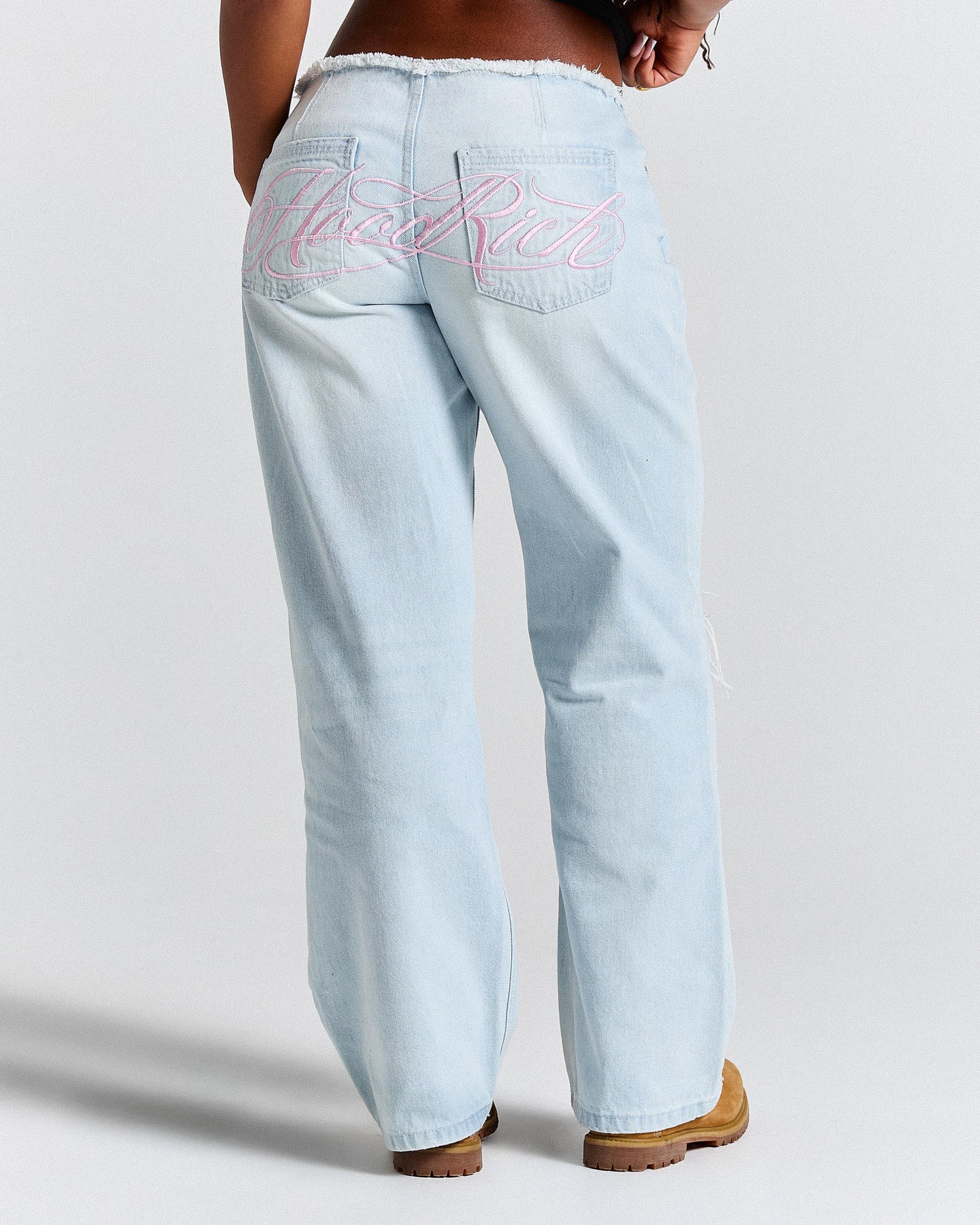 Light blue jeans with visible branding on a plain background