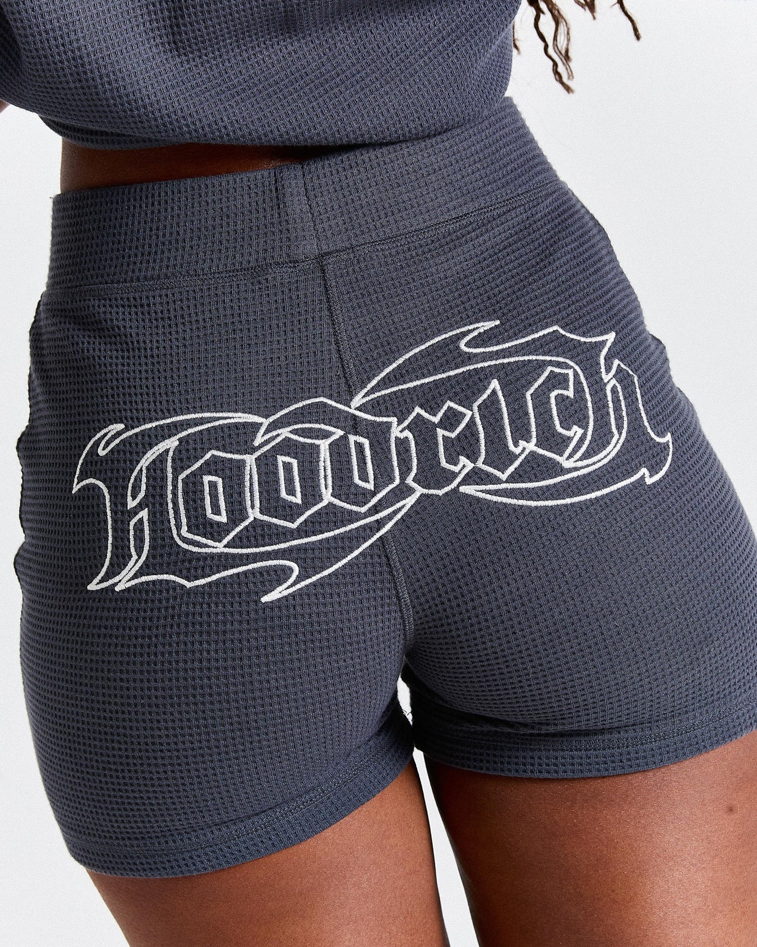 Dark gray shorts with white graphic design on a light gray background