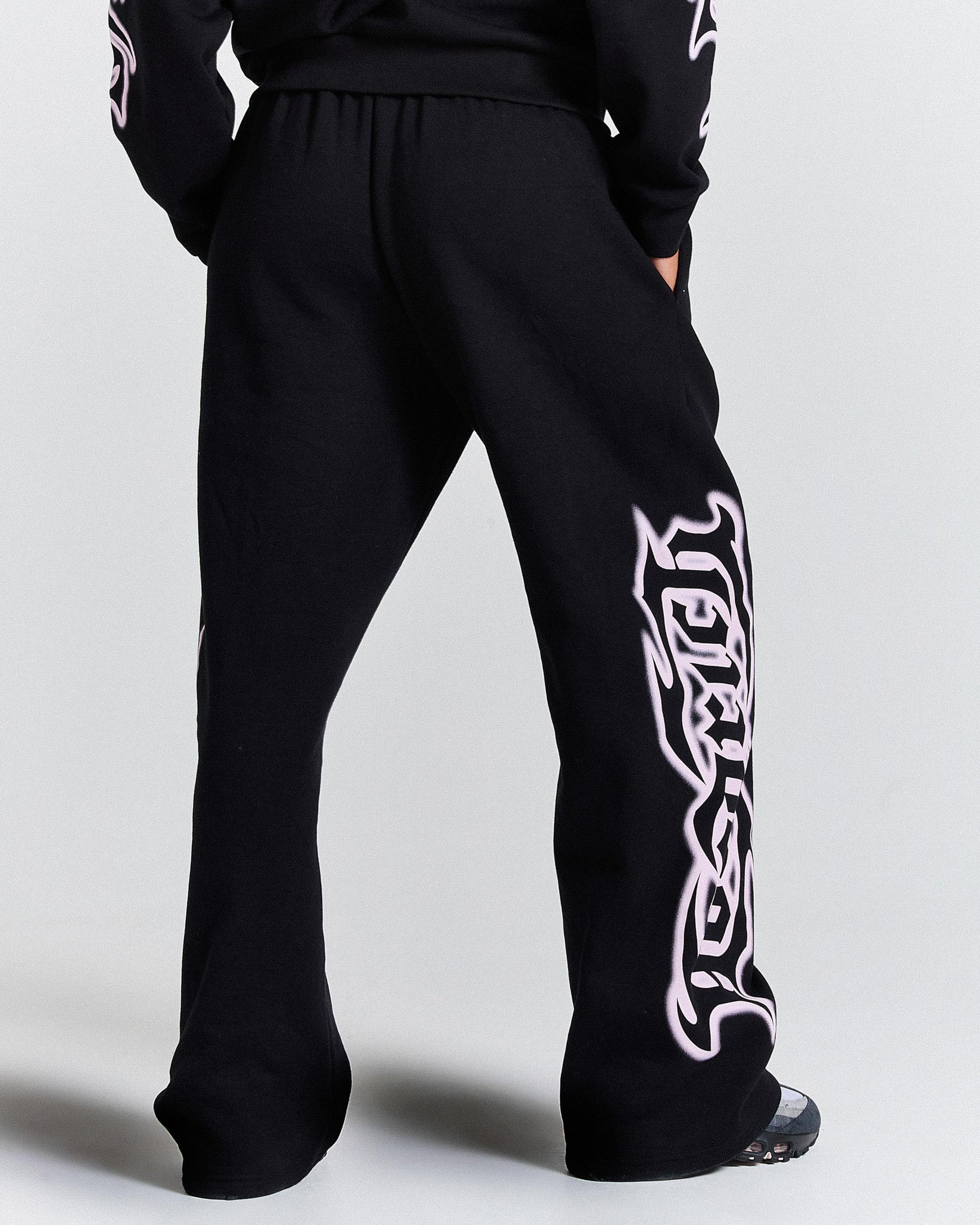 Black sweatpants with white tribal design on a light gray background