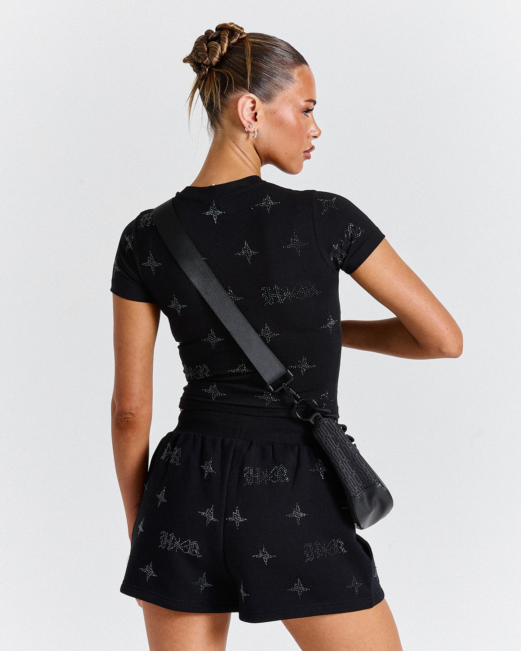 Woman wearing a black outfit with star patterns against a white background