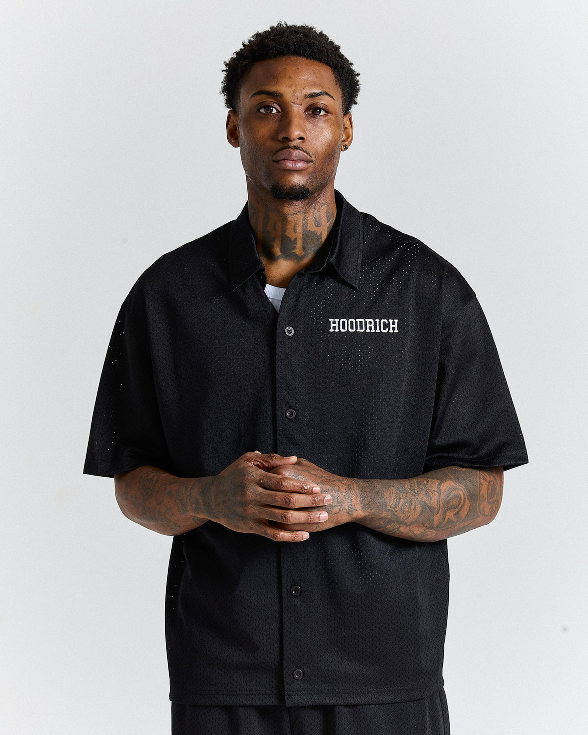 Man wearing a black shirt with 'Hoodrich' logo on a white background