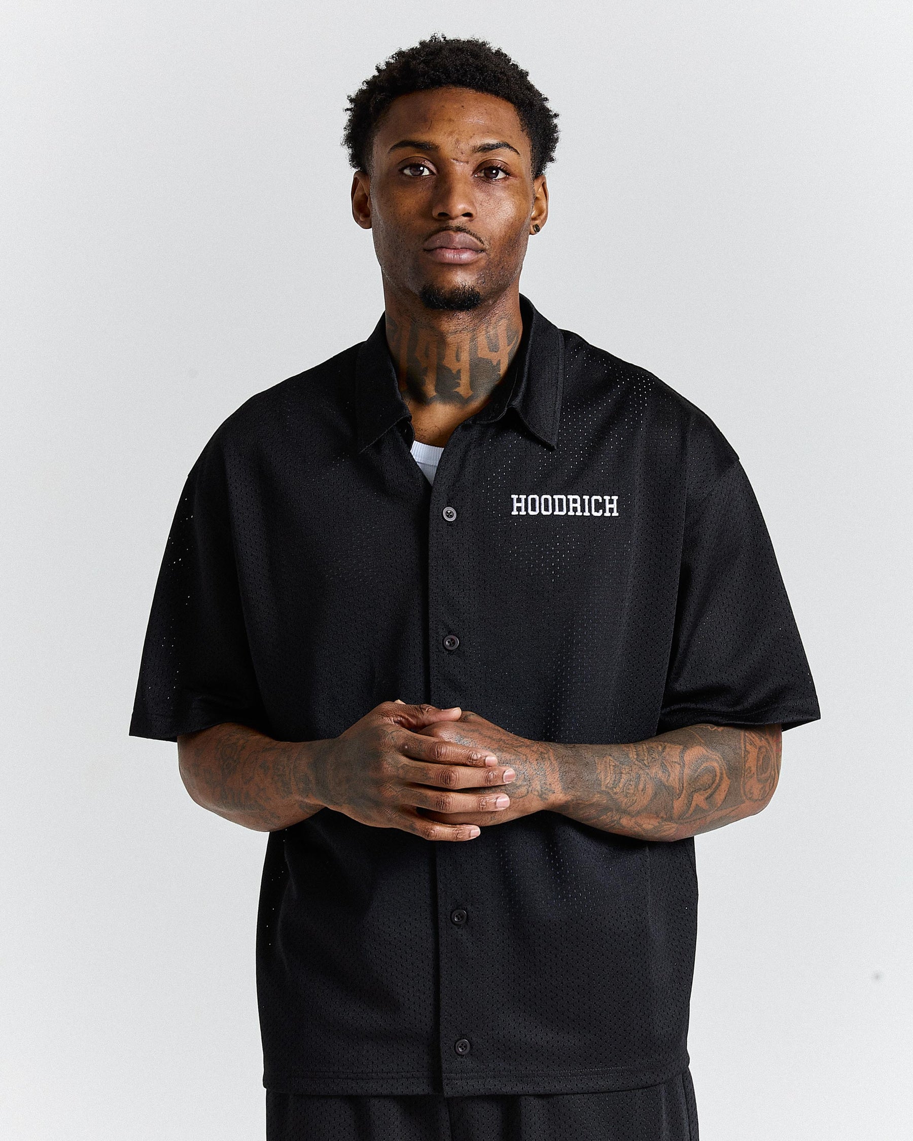 Man wearing a black shirt with 'Hoodrich' logo on a white background