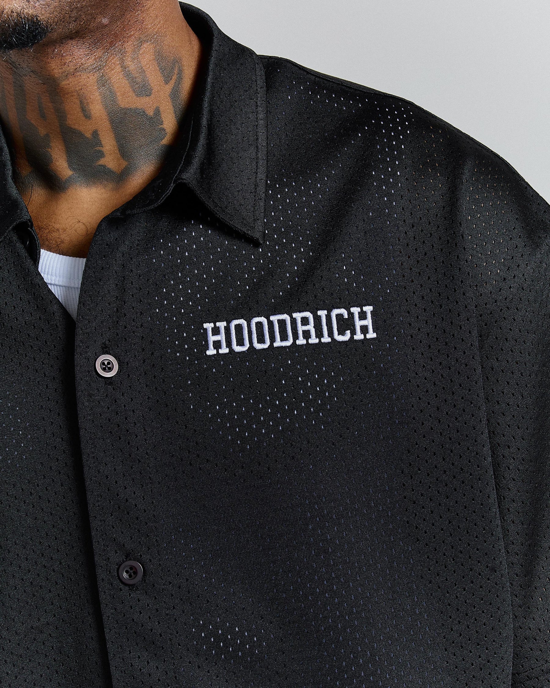 Black perforated jacket with 'Hoodrich' branding on a gray background