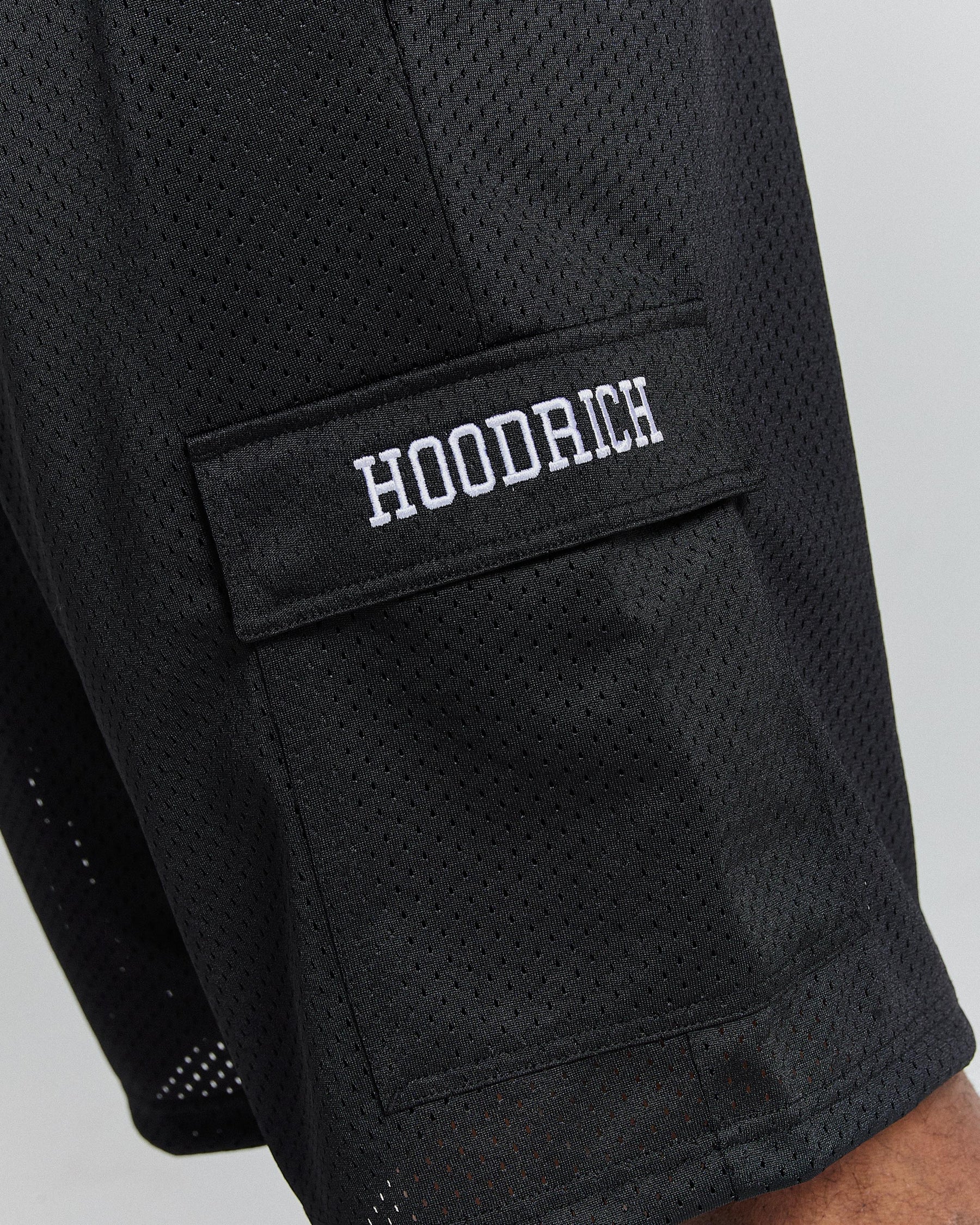 Black mesh shorts with 'HOODRICH' logo on a gray background