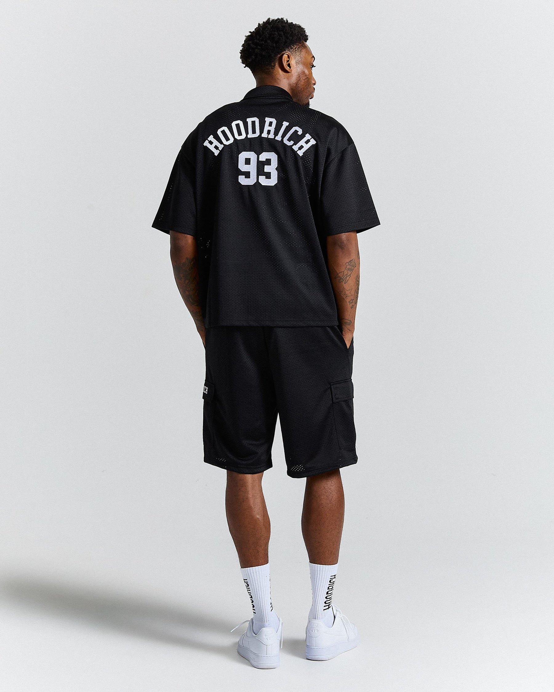 Person wearing a black sports outfit with 'Hoodrich' and number '93' on a plain background