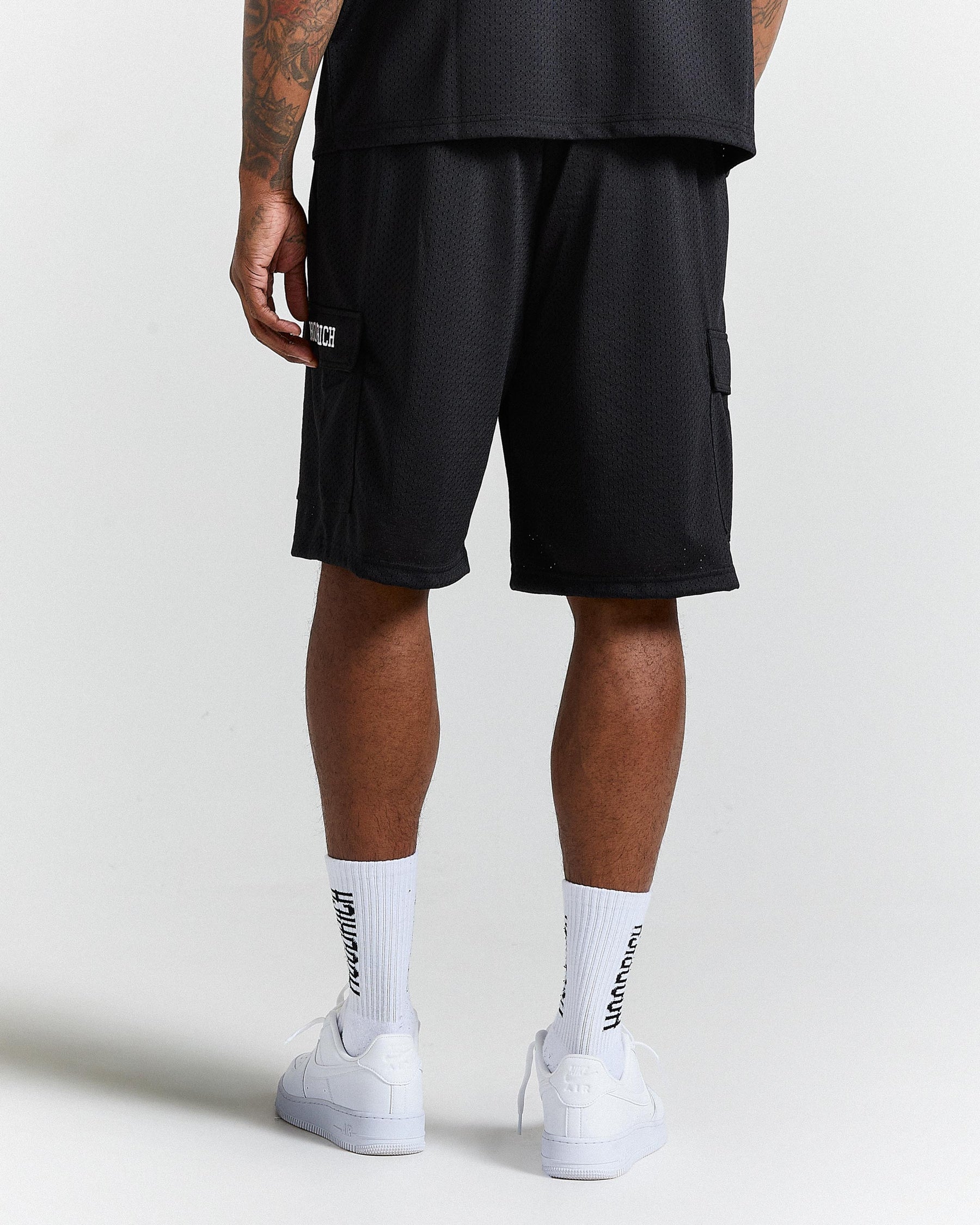 Person wearing black shorts and white socks with text on a light gray background