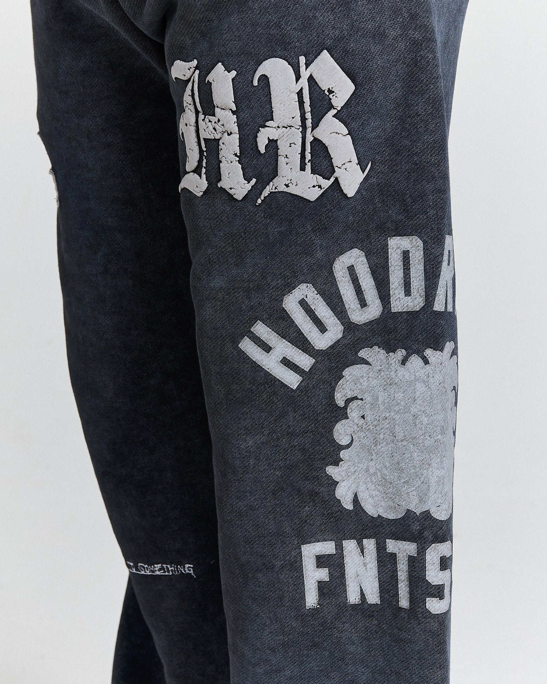 Dark gray sweatpants with white text and logo on a light gray background