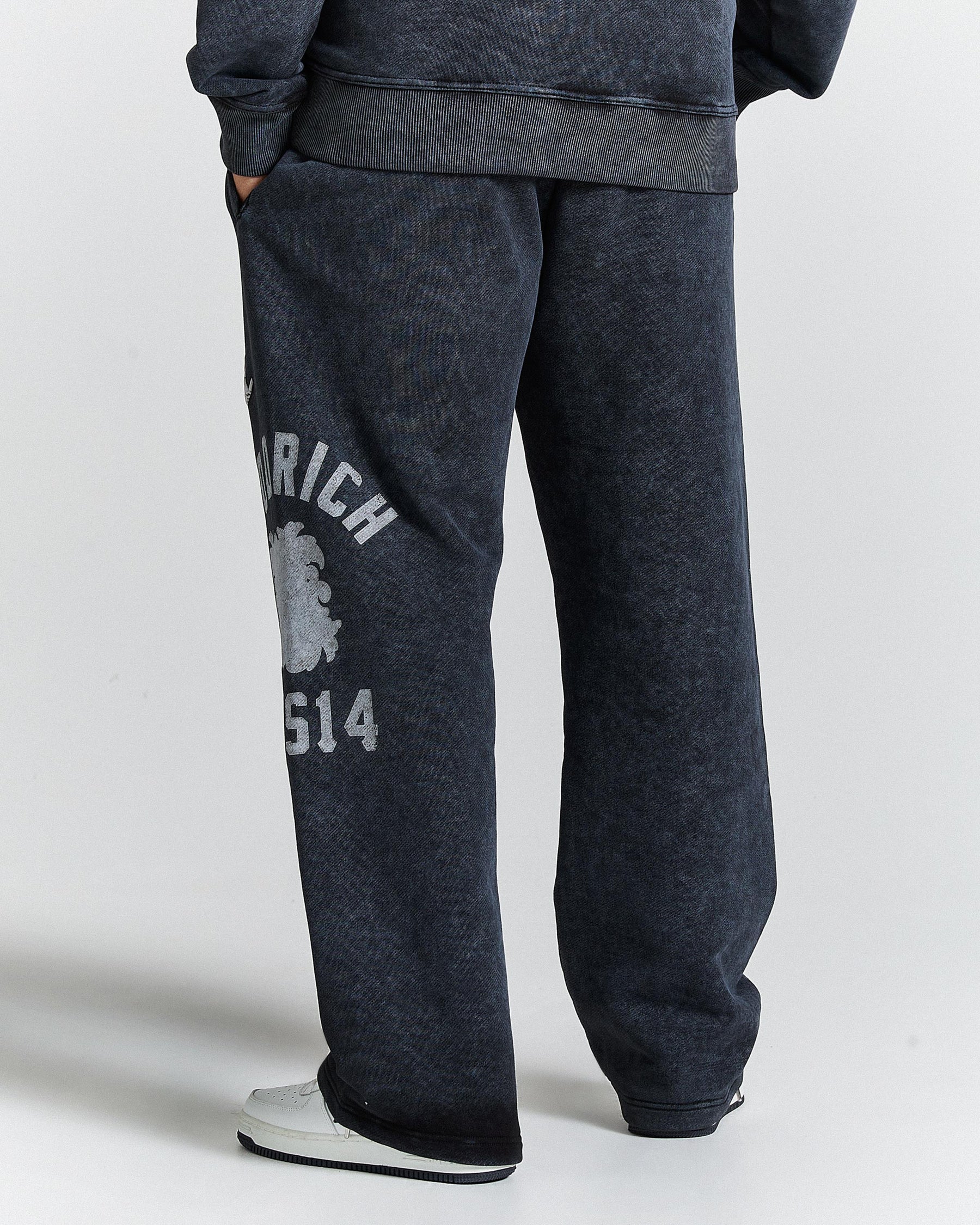 Dark gray sweatpants with a logo and text on a white background