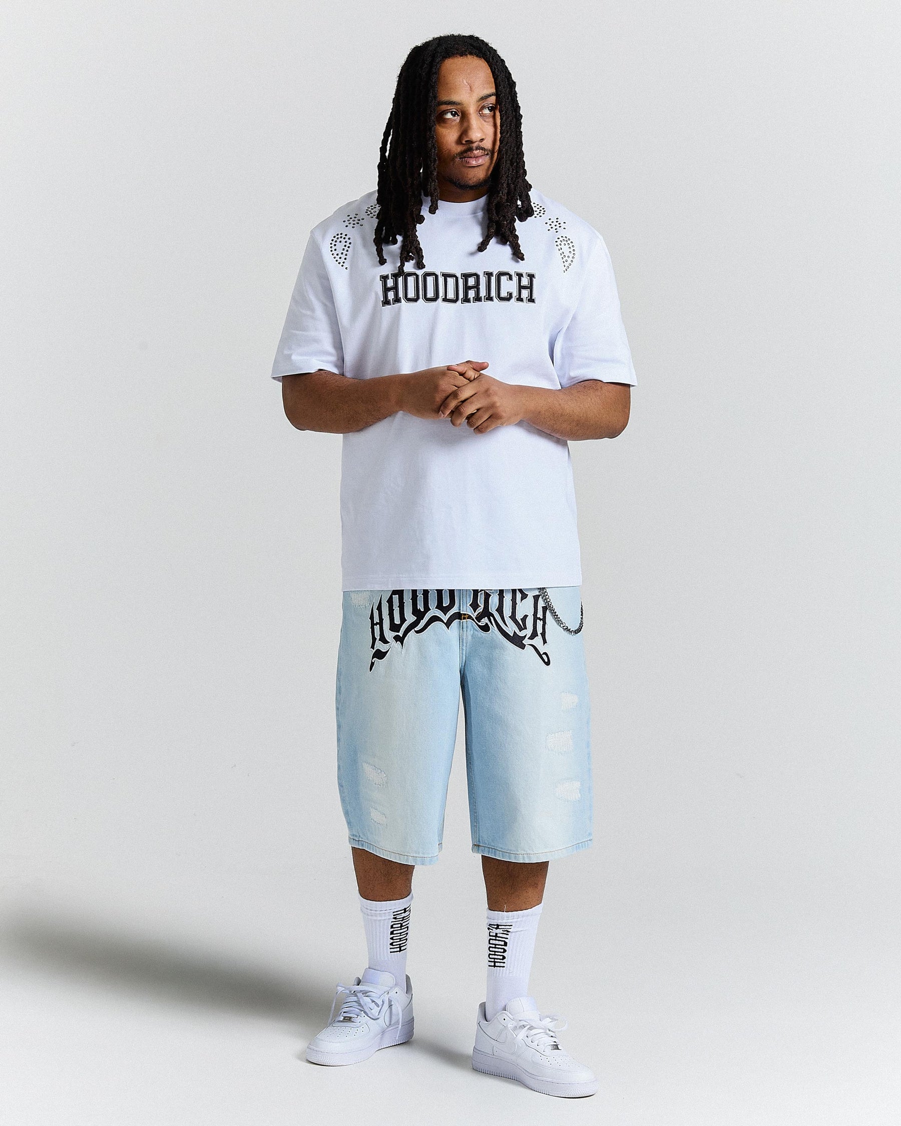 Person wearing a white t-shirt and light blue shorts with 'Hoodrich' branding on a plain background