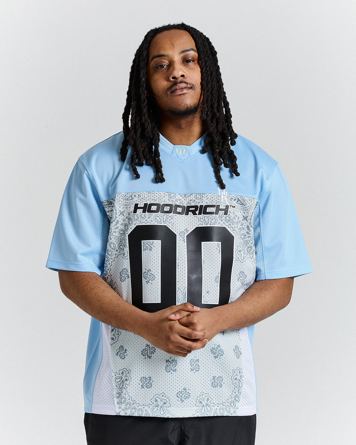 Person wearing a light blue t-shirt with 'HOODRICH' branding and design.