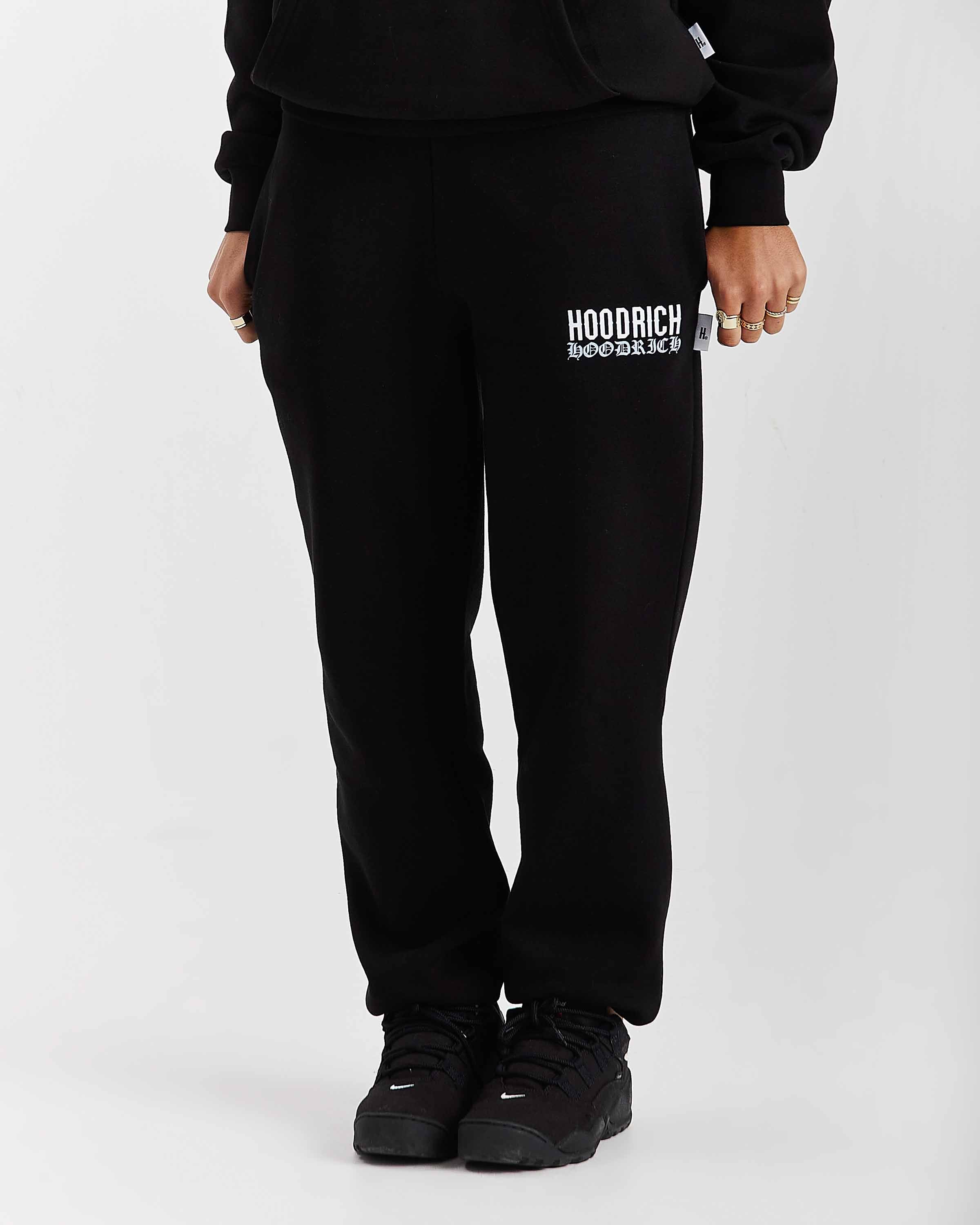 Person wearing black sweatpants with 'Hoodrich' logo on a white background