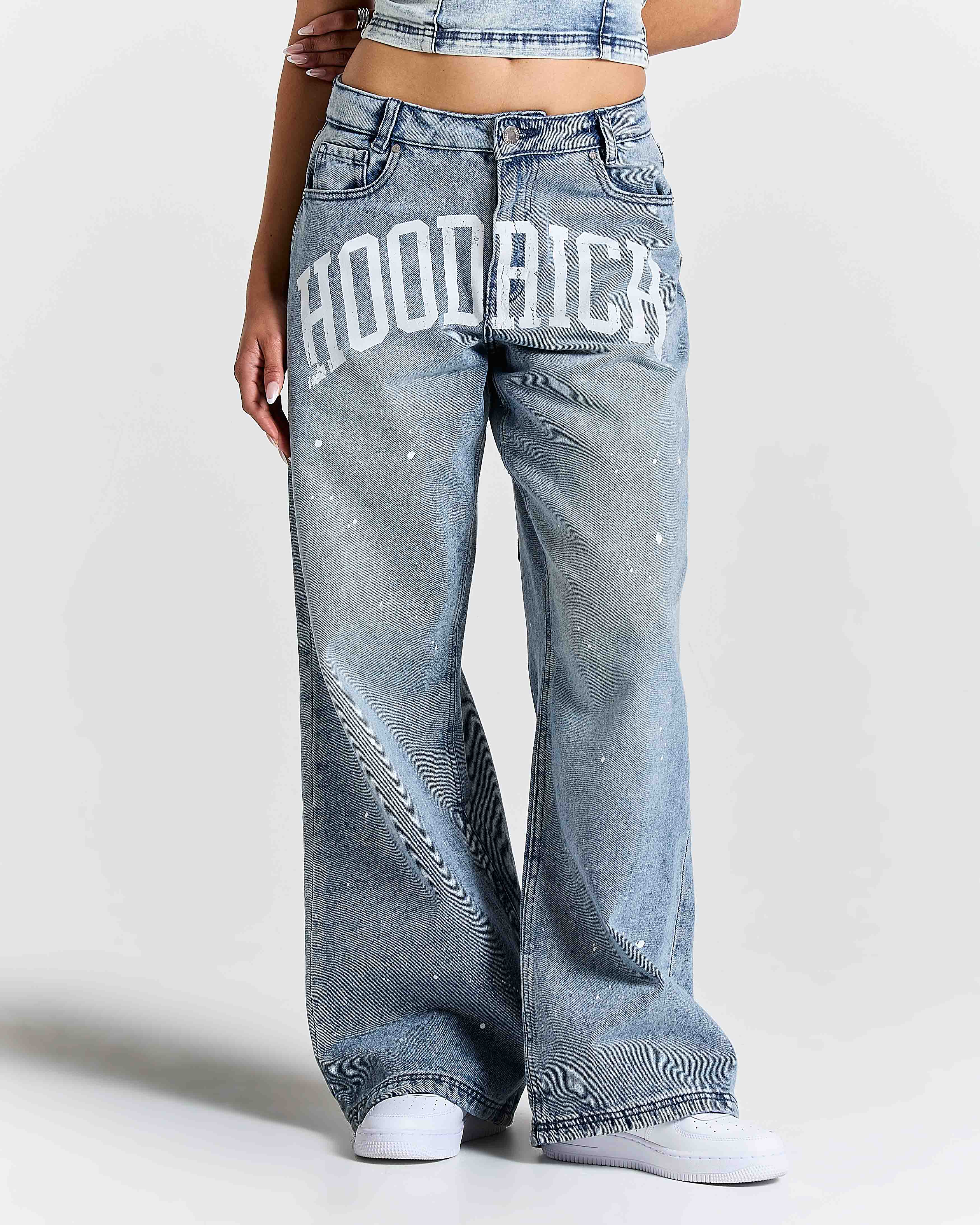 Person wearing light blue jeans with 'HOODRICH' text on a white background